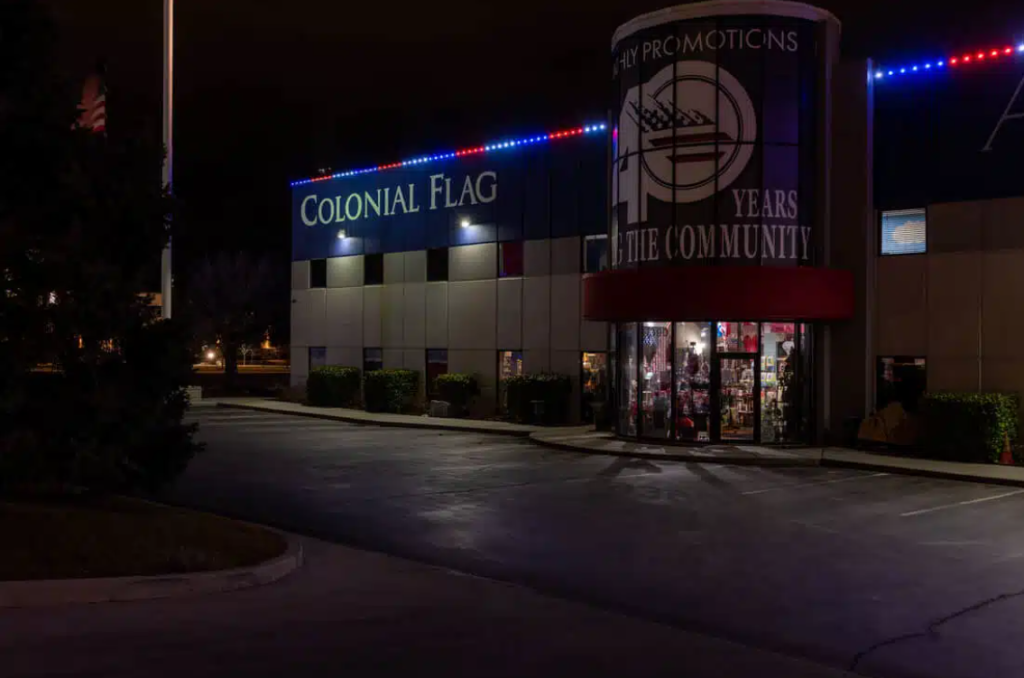 permanent exterior lighting that's red, white, and blue on the outside of a business named Colonial Flag