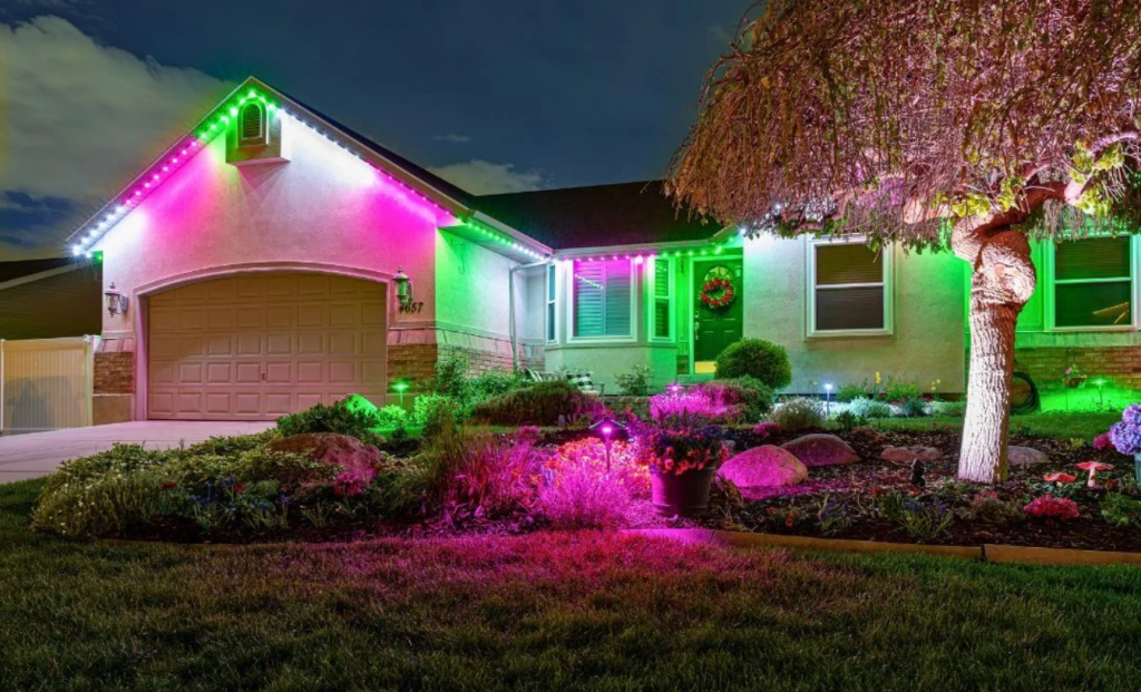 Outside of ahome with pink and green color changing landscape lights and permanent exterior lighting 