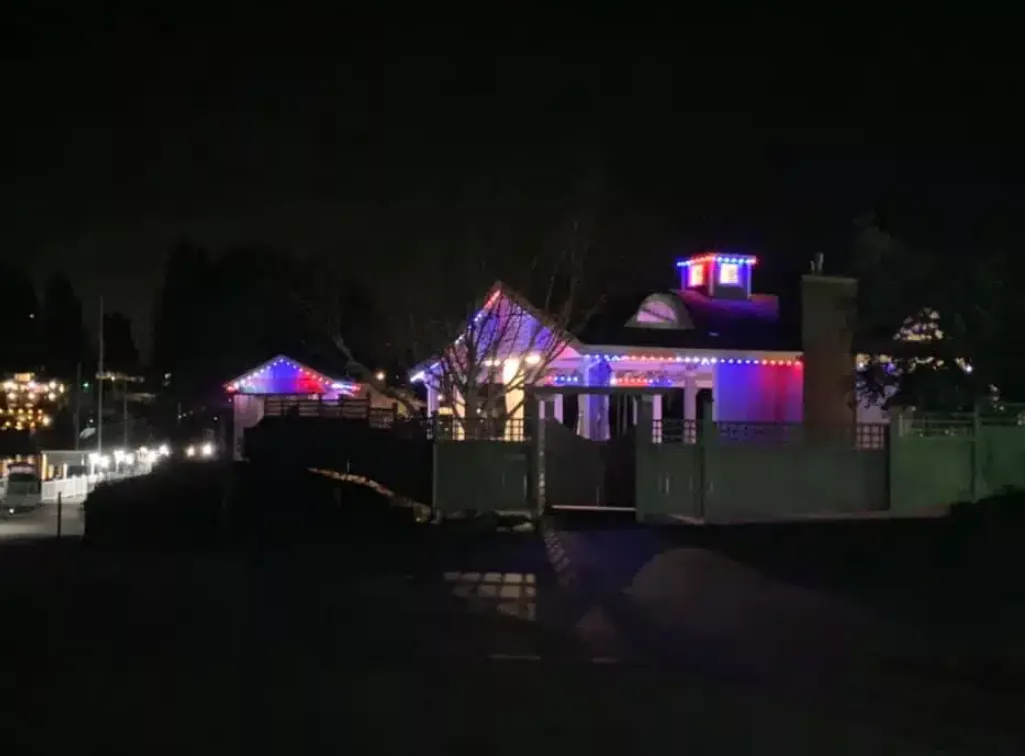 a long shot of home lit up with red, white, and blue lights on its exterior